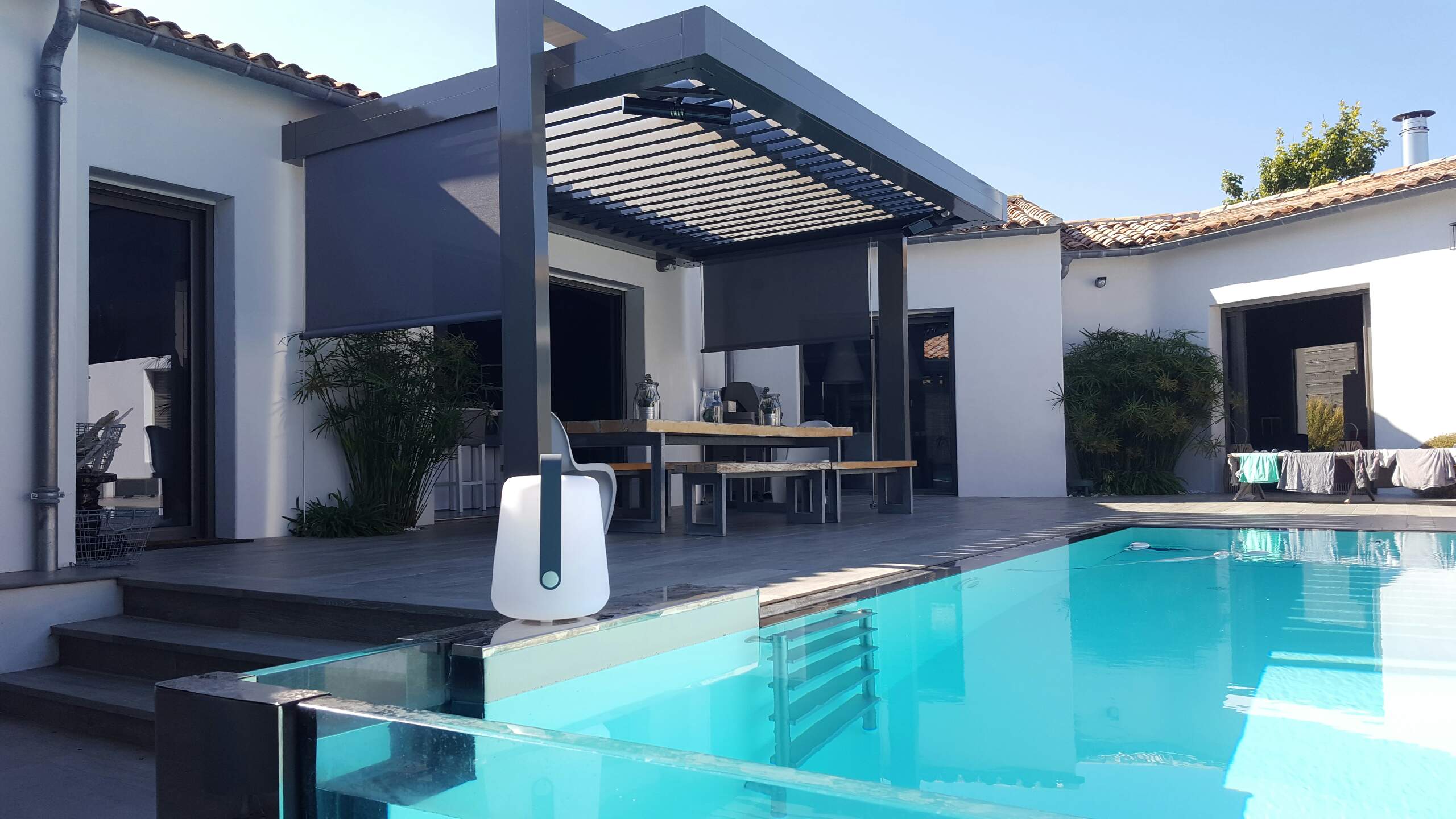 pergola open avec arche avec store protection en screen qui laisse passer l'air mais pas la chaleur